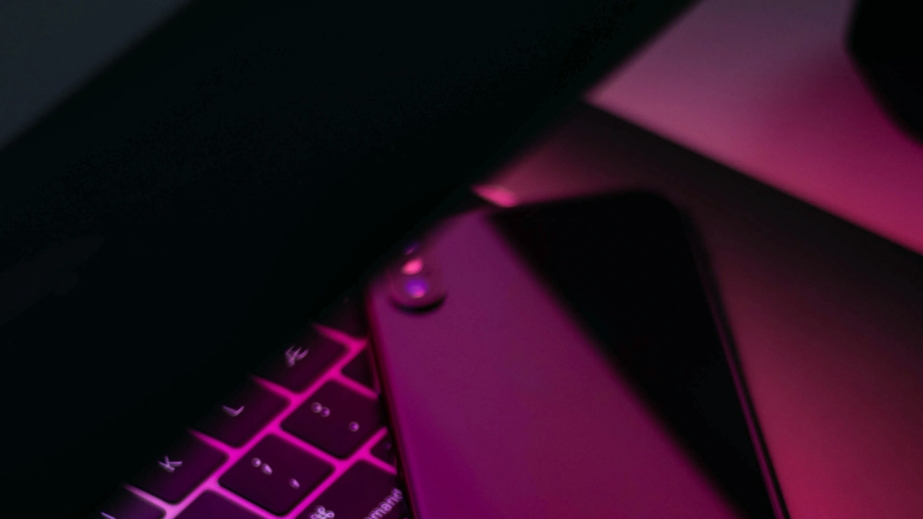 Smartphone on a neon-lit laptop keyboard in magenta light, ZOOM-IN MWC 2019 trendreport cover