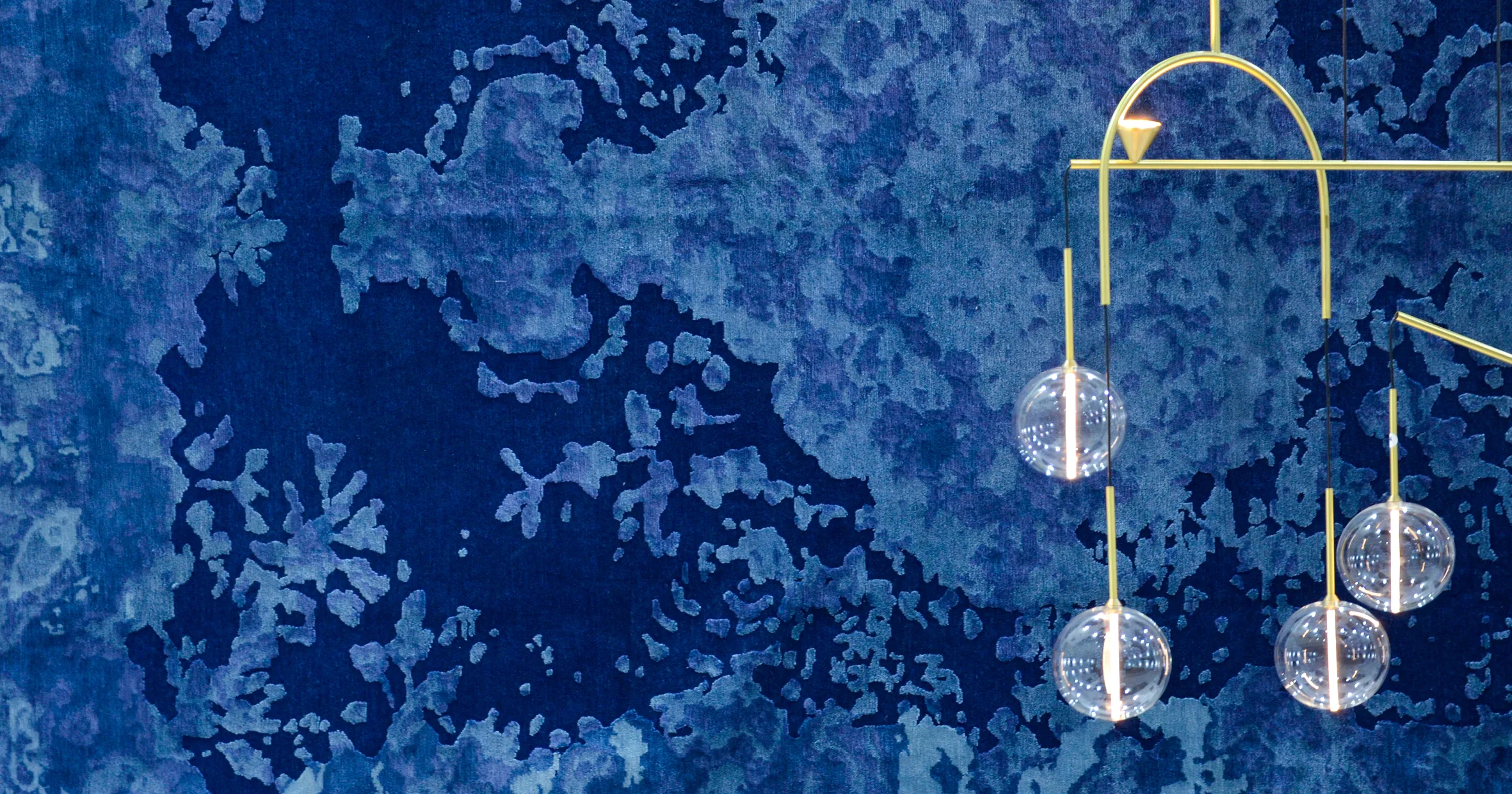 Salone del Mobile Milano 2019 cover with a gold pendant lamp against a deep blue textured marble background