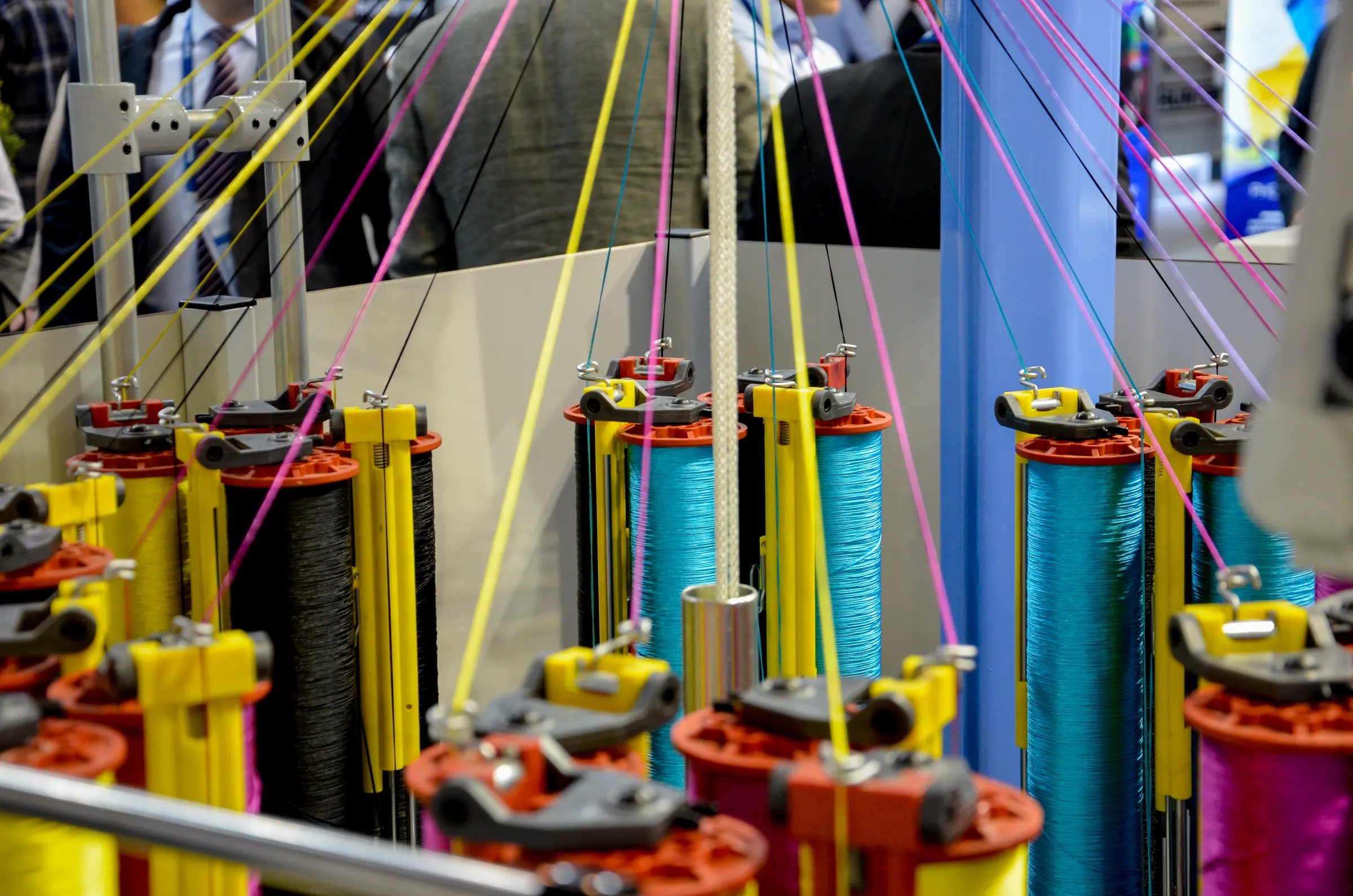 Close-up of industrial textile machinery with colourful yarn spools at Techtextil 2019 Frankfurt