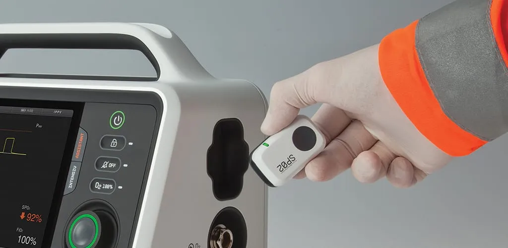 Sanitäter in Warnschutzjacke steckt kabellosen SpO2-Pulsoximeter-Modul in das RESCUE-Beatmungsgerät