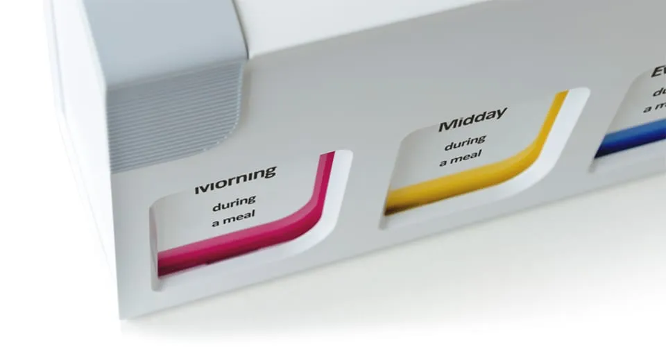 Nahaufnahme des mediTimers mit den geschwungenen farbcodierten Beschriftungsmulden für Morgen- und Mittagsdosis