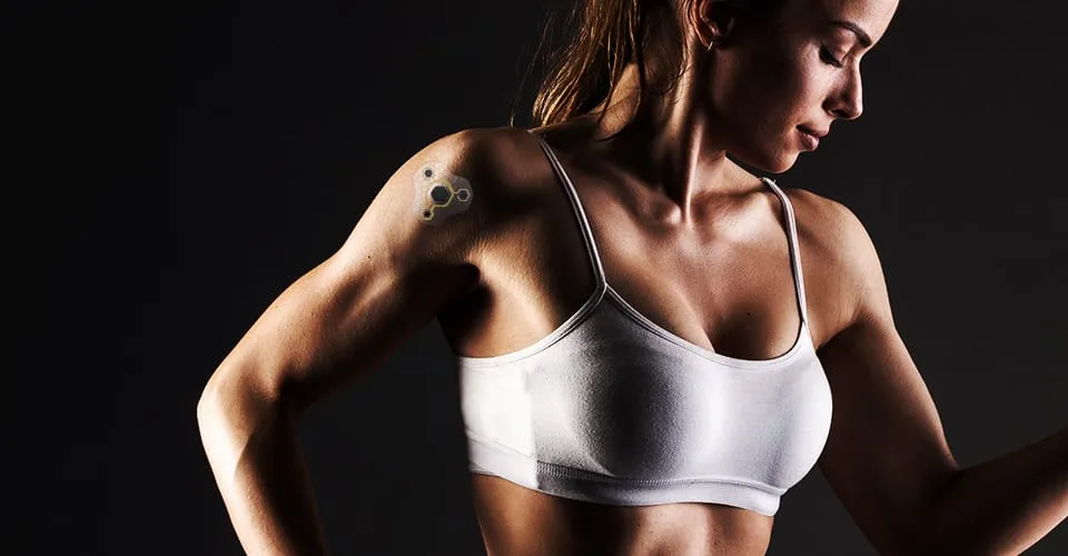 Woman wearing Covestro Patch 3D-printed wearable on shoulder, dark studio background
