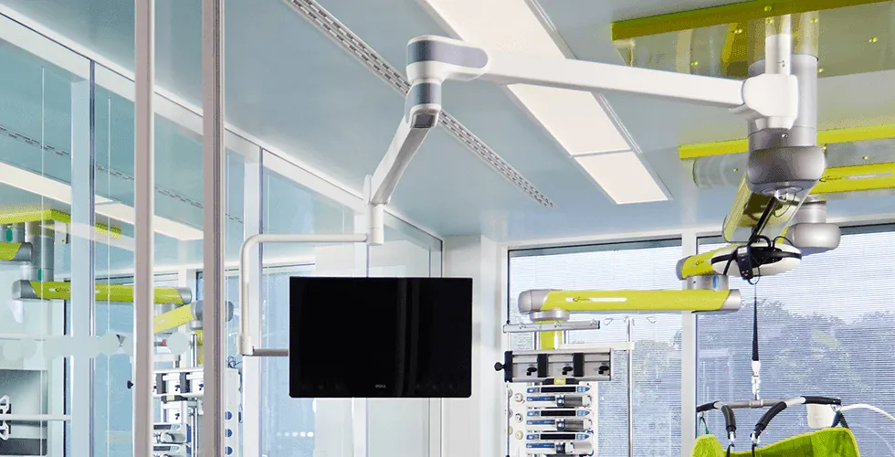 VALIA system installed in a modern OR: Ondal pendant arms with green accents above surgical workstations