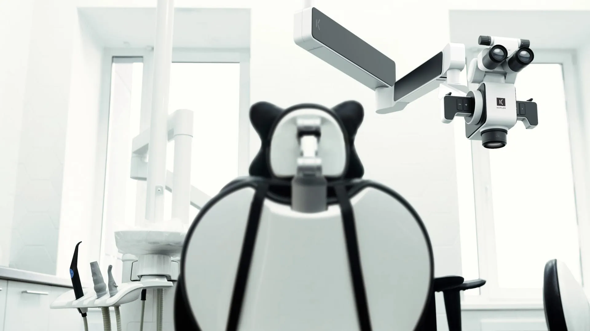 KEPLER dental microscope mounted on ceiling arm above a patient chair in a bright modern treatment room