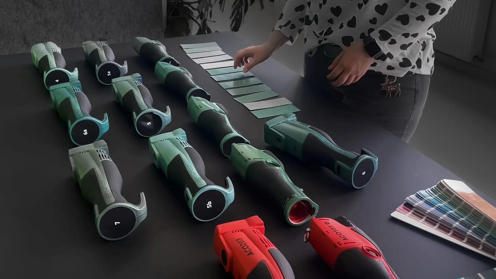 Farbworkshop der NOVOPRESS 32 Pressmaschine: Prototypen in Grüntönen auf einem Tisch mit Farbfächern